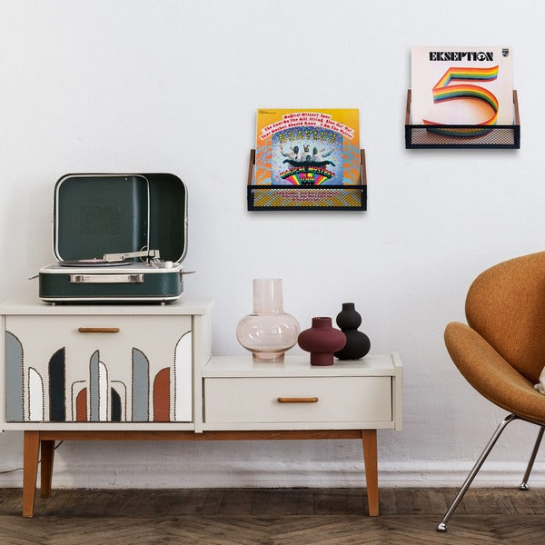 2 Hamilton Max vinyl record shelves mounted on a wall holding records and near a record player sitting on a side table