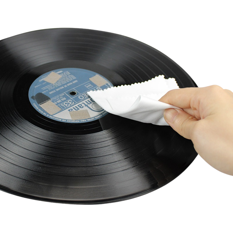 A hand holding the vinyl survival cleaning cloth, wiping a vinyl record