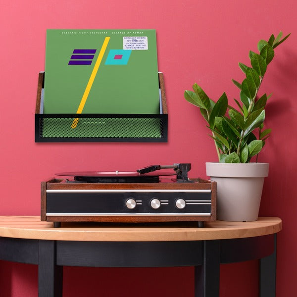 One record shelf mounted on wall with records, over a record player on a side table